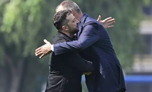 Ukrainian President Volodymyr Zelenskyy, left, is welcomed by German Chancellor Friedrich Merz upon arrival in the garden of the chancellery in Berlin, Germany, Wednesday, Aug. 13, 2025 to join a video conference of European leaders with the US President on the Ukraine war. (John MacDougall/Pool Photo via AP)