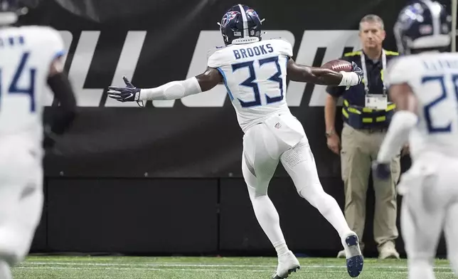 Tennessee Titans defensive back Kendell Brooks (33) celebrates as he returns an interception for a touchdown during the first half of a preseason NFL football game against the Atlanta Falcons, Friday, Aug. 15, 2025, in Atlanta. (AP Photo/Mike Stewart)