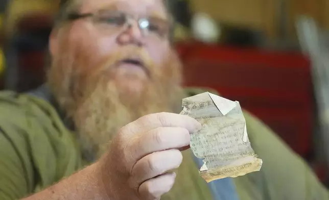 Richard Guilford holds up a lottery ticket he purchased 11 years ago during an interview Thursday, Aug. 14, 2025, in Petersburg, Mich. (AP Photo/Ryan Sun)