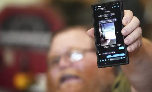 Richard Guilford holds up a chat message he received from Chad Volk during an interview Thursday, Aug. 14, 2025, in Petersburg, Mich. (AP Photo/Ryan Sun)