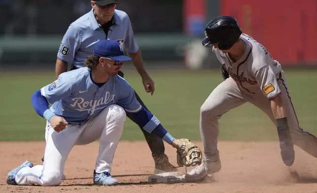 Atlanta Braves' Luke Williams, right, beats the tag by Kansas City Royals shortstop Bobby Witt Jr. to steal second during the eighth inning of a baseball game Wednesday, July 30, 2025, in Kansas City, Mo. (AP Photo/Charlie Riedel)
