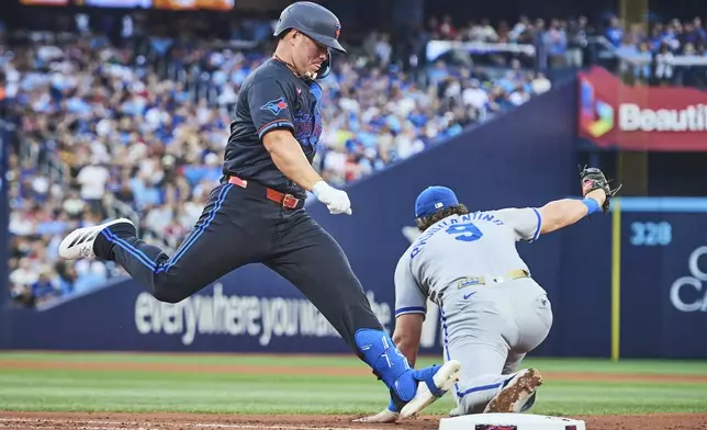 Toronto Blue Jays' Daulton Varsho, left, is out as Kansas City Royals first baseman Vinnie Pasquantino (9) makes a catch during fourth-inning baseball game action in Toronto, Friday, Aug. 1, 2025. (Sammy Kogan/The Canadian Press via AP)