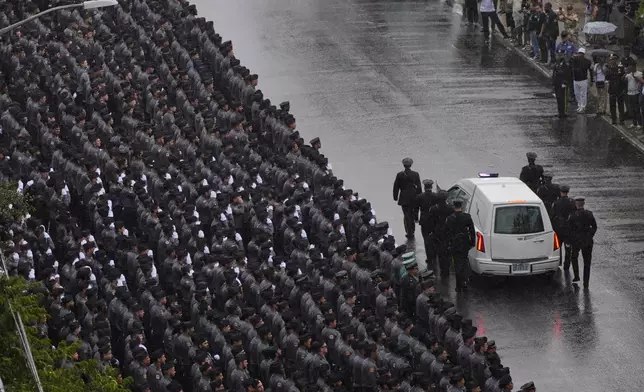 New York Police officers salute as the hearse carrying the casket of NYPD officer Didarul Islam passes after his funeral, Thursday, July 31, 2025, in New York. (AP Photo/Yuki Iwamura )