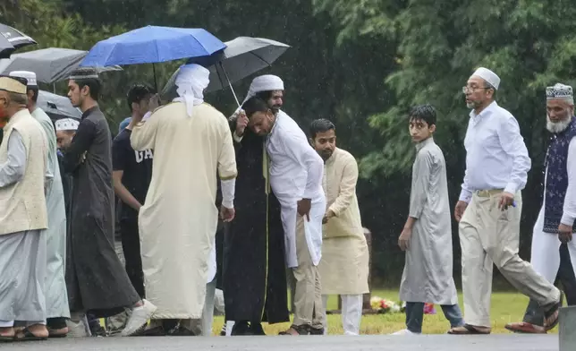 Mourners comfort one another as they leave the cemetery after the burial of NYPD officer Didarul Islam in Totowa, N.J., Thursday, July 31, 2025. (AP Photo/Seth Wenig)