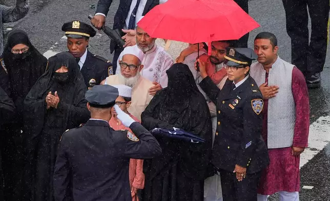 Didarul Islam's wife is presented with an American flag after her husband's funeral, Thursday, July 31, 2025, in New York. (AP Photo/Yuki Iwamura )