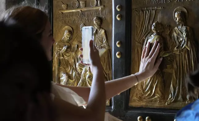 Faithful walk through the St. Peter's Basilica holy door on the occasion of the Youth Jubilee at the Vatican, Tuesday, July 29, 2025. (AP Photo/Gregorio Borgia)