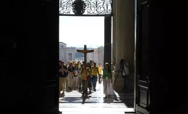Faithful walk through the St. Peter's Basilica holy door on the occasion of the Youth Jubilee at the Vatican, Tuesday, July 29, 2025. (AP Photo/Gregorio Borgia)