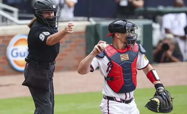 Home plate umpire Jen Pawol calls a strike during the first inning of a baseball game between the Miami Marlins and Atlanta Braves, Sunday, Aug. 10, 2025, in Atlanta. (AP Photo/Colin Hubbard)