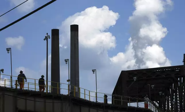 Steelworkers cross a bridge to the the Clairton Coke Works, a U.S. Steel plant, in Clairton, Pa., Tuesday, Aug. 12, 2025. (AP Photo/Gene J. Puskar)