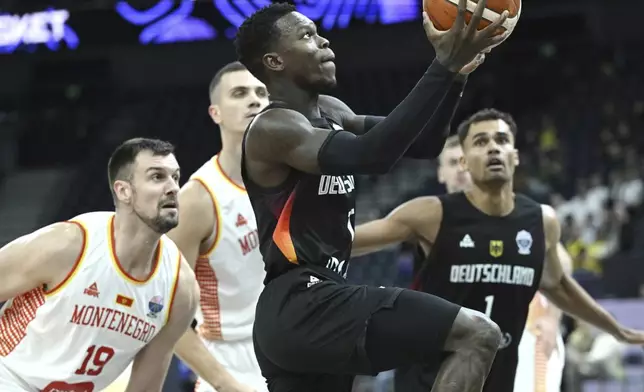 Germany's Dennis Schroder, front, plays the ball during the FIBA EuroBasket 2025 group B basketball match between Montenegro and Germany in Tampere, Finland, Wednesday, Aug. 27, 2025. (Heikki Saukkomaa/Lehtikuva via AP)
