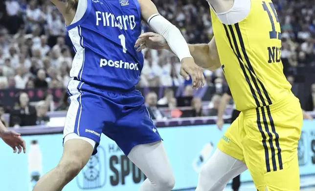 Finland's Miro Little, left, and Sweden's Mattias Markusson during the basketball FIBA EuroBasket 2025 group B match between Sweden and Finland in Tampere, Finland, Wednesday Aug. 27, 2025. (Heikki Saukkomaa/Lehtikuva via AP)