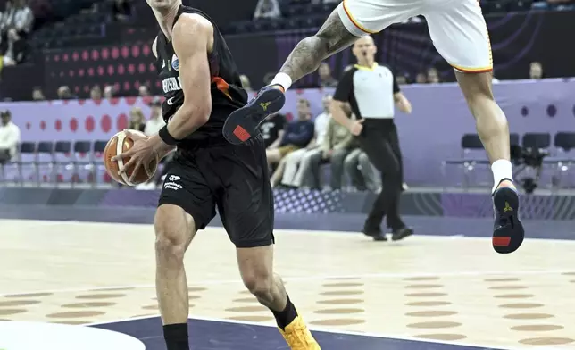 Germany's Franz Wagner, left, and Montenegro's Kyle Allman, right, challenge for the ball during the FIBA EuroBasket 2025 group B basketball match between Montenegro and Germany in Tampere, Finland, Wednesday, Aug. 27, 2025. (Heikki Saukkomaa/Lehtikuva via AP)