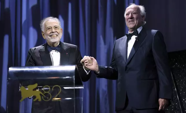 Francis Ford Coppola, left, presents the Golden Lion for lifetime achievement to Werner Herzog during the opening ceremony and the premiere of the film 'La Grazia' during the 82nd edition of the Venice Film Festival in Venice, Italy, on Wednesday, Aug. 27, 2025. (Photo by Scott A Garfitt/Invision/AP)