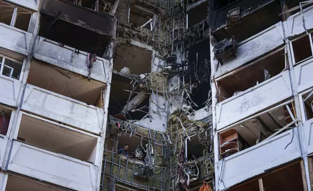 A man is seen among rubble from his apartment damaged by a Russian strike in Kyiv, Ukraine, on Thursday, Aug. 28, 2025. (AP Photo/Evgeniy Maloletka)
