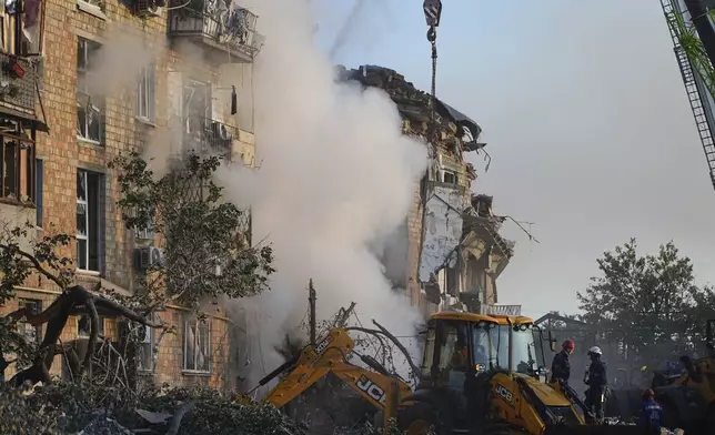 Firefighters work at the site of a burning building after a Russian attack in Kyiv, Ukraine, Thursday, Aug. 28, 2025. (AP Photo/Efrem Lukatsky)