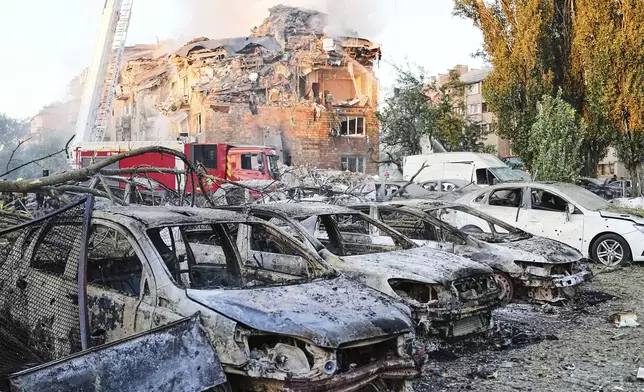 Firefighters work on the site of a burning building after a Russian attack in Kyiv, Ukraine, early Thursday, Aug. 28, 2025. (AP Photo/Efrem Lukatsky)