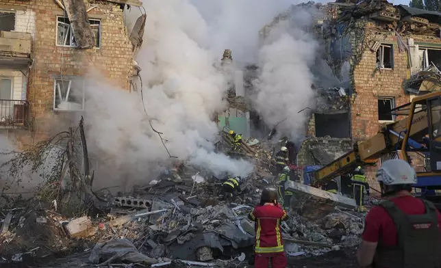 Firefighters work at the site of a burning building after a Russian attack in Kyiv, Ukraine, Thursday, Aug. 28, 2025. (AP Photo/Efrem Lukatsky)