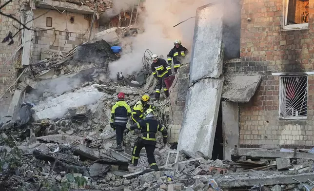 Firefighters work on the site of a burning building after a Russian attack in Kyiv, Ukraine, early Thursday, Aug. 28, 2025. (AP Photo/Efrem Lukatsky)