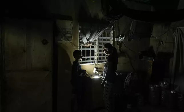 Jhonkeiber Romero, one of five children who returned to Venezuela from Mexico with their parents after abandoning plans to reach the United States amid President Donald Trump's migration crackdown, talks to his grandmother at their home in Maracaibo, Venezuela, Monday, June 16, 2025. (AP Photo/Matias Delacroix)