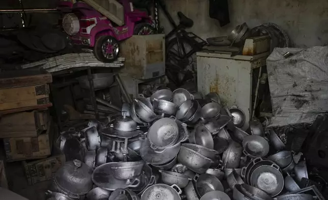 Aluminum pots made by the Romero Perez family, who returned to Venezuela from Mexico after abandoning plans to reach the United States amid President Donald Trump's migration crackdown, sit in a pile at their workshop in Maracaibo, Venezuela, Monday, June 16, 2025. (AP Photo/Matias Delacroix)
