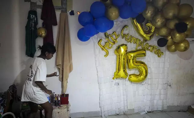 Yaribel Romero, one of five children who returned to Venezuela from Mexico with their parents after abandoning plans to reach the United States amid President Donald Trump's migration crackdown, tidies her room the day after her fifteenth birthday, in Maracaibo, Venezuela, Monday, June 16, 2025. (AP Photo/Matias Delacroix)