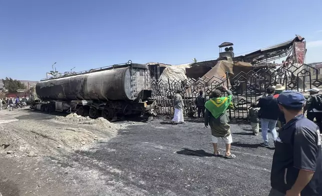 People watch damaged vehicles and buildings a day after Israeli airstrikes on the main gas station in Sanaa, Yemen, Monday, Aug. 25, 2025. (AP Photo)