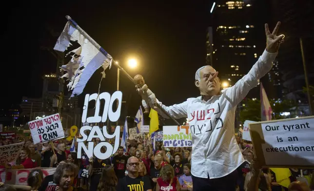 A demonstrator takes part in a performance during a protest against Prime Minister Benjamin Netanyahu's government and calling for the release of hostages held in the Gaza Strip by the Hamas militant group, in Tel Aviv, Israel, Saturday, Aug. 23, 2025. (AP Photo/Ohad Zwigenberg)