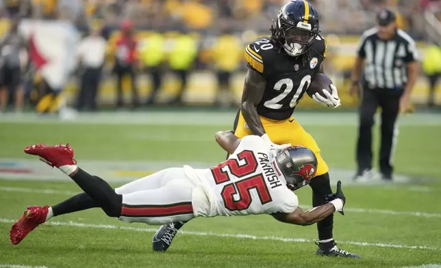 Pittsburgh Steelers running back Kaleb Johnson (20) is tackled by Tampa Bay Buccaneers cornerback Jacob Parrish (25) during the first half of an NFL football preseason game, Saturday, Aug. 16, 2025 in Pittsburgh. (AP Photo/Sue Ogrocki)
