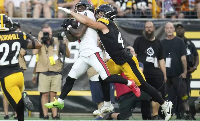 Tampa Bay Buccaneers running back Bucky Irving catches a pass from quarterback Teddy Bridgewater for a touchdown with Pittsburgh Steelers linebacker Payton Wilson defending during the first half of an NFL football preseason game, Saturday, Aug. 16, 2025 in Pittsburgh. (AP Photo/Sue Ogrocki)
