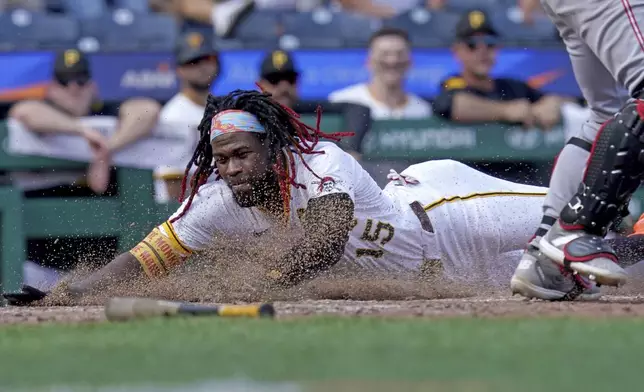 Pittsburgh Pirates' Oneil Cruz scores during the eighth inning of a baseball game against the Cincinnati Reds, Sunday, Aug. 10, 2025, in Pittsburgh. (AP Photo/Matt Freed)
