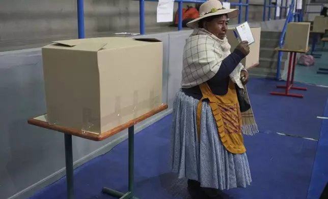 A voters displays her ballot during general elections in La Paz, Bolivia, Sunday, Aug. 17, 2025. (AP Photo/Natacha Pisarenko)