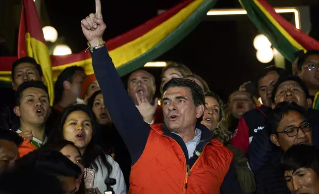 Presidential candidate Rodrigo Paz, center, addresses supporters after early results showed him leading in the presidential election in La Paz, Bolivia, Sunday, Aug. 17, 2025. (AP Photo/Freddy Barragan)