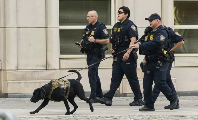 Department of Homeland Security Police and their dog patrol outside Federal court in the Brooklyn borough of New York, Monday, Aug. 25, 2025. (AP Photo/Richard Drew)
