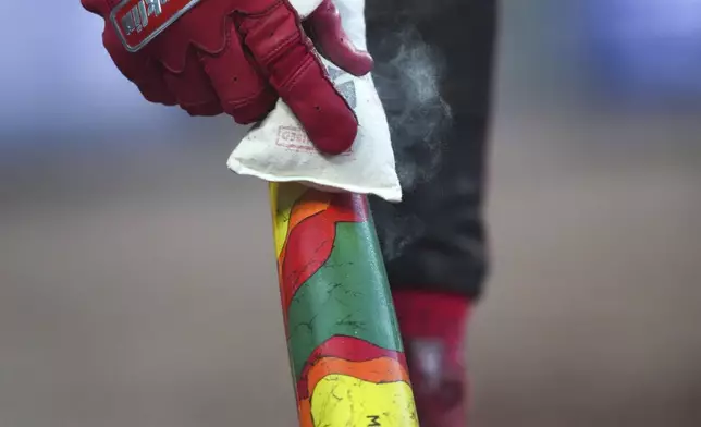 Cincinnati Reds' Miguel Andujar prepares a special bat for Players' Weekend in the fourth inning of a baseball game against the Milwaukee Brewers, Friday, Aug. 15, 2025, in Cincinnati. (AP Photo/Kareem Elgazzar)