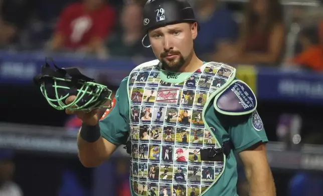 Seattle Mariners catcher Cal Raleigh wears a custom chest protector featuring Little League photos of his teammates for Player's Weekend during the second inning of the Little League Classic baseball game against the New York Mets at Bowman Field in Williamsport, Pa., Sunday, Aug. 17, 2025. (AP Photo/Gene J. Puskar)
