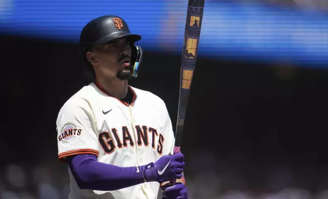 San Francisco Giants' Willy Adames walks to the plate with his custom bat during the first inning of a baseball game against the Tampa Bay Rays in San Francisco, Sunday, Aug. 17, 2025. (AP Photo/Jeff Chiu)