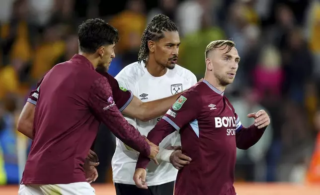 West Ham United's Jarrod Bowen, right, is pulled away from the fans after an argument at the final whistle in the English League Cup second round soccer match against the Wolverhampton Wanderers, Tuesday, Aug. 26, 2025, at Molineux Stadium in Wolverhampton, England. (Mike Egerton/PA via AP)