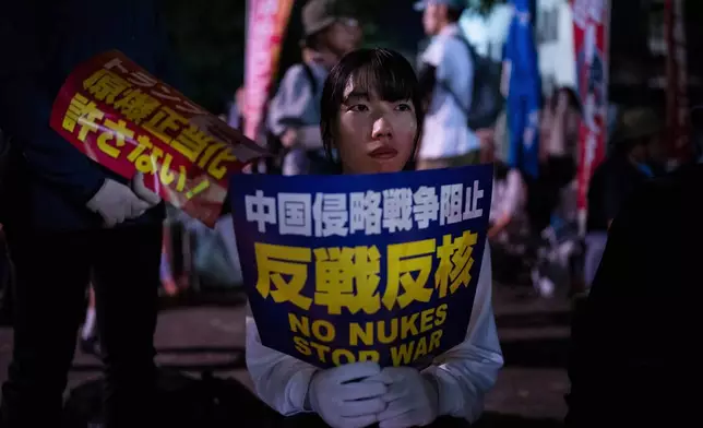 Protesters sit outside the Atomic Bomb Dome ahead of the memorial service to mark the 80th anniversary of the WWII U.S. atomic bombing in Hiroshima, Wednesday, August 6, 2025. (AP Photo/Louise Delmotte)