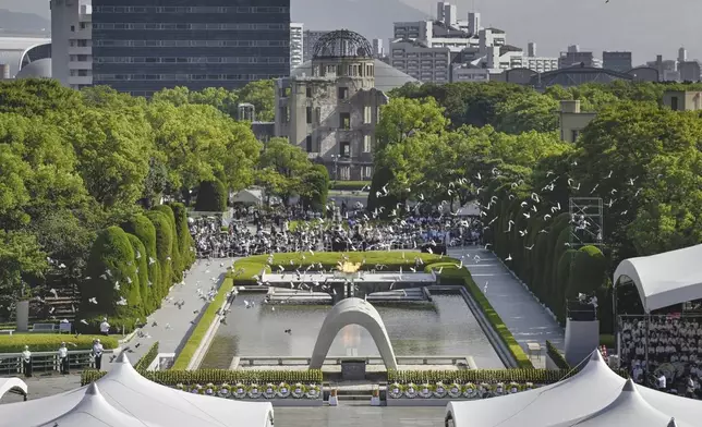 Doves fly over the cenotaph dedicated to the victims of the atomic bombing at the Hiroshima Peace Memorial Park during a ceremony to mark the 80th anniversary of the bombing in Hiroshima, western Japan, Wednesday, Aug. 6, 2025. (Kyodo News via AP)