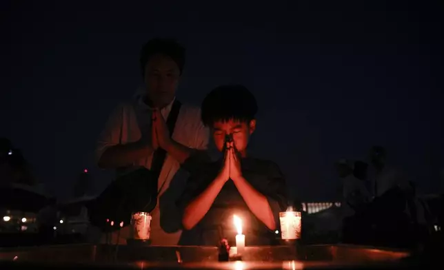 A child prays at the Peace Memorial Park ahead of the memorial service to mark the 80th anniversary of the WWII U.S. atomic bombing in Hiroshima, Wednesday, Aug. 6, 2025, in Japan. (AP Photo/Louise Delmotte)