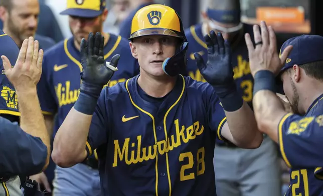Milwaukee Brewers' Andrew Vaughn (28) high-fives teammates in the dugout after hitting a solo home run in the fourth inning of a baseball game against the Atlanta Braves, Wednesday, Aug. 6, 2025, in Atlanta. (AP Photo/Colin Hubbard)