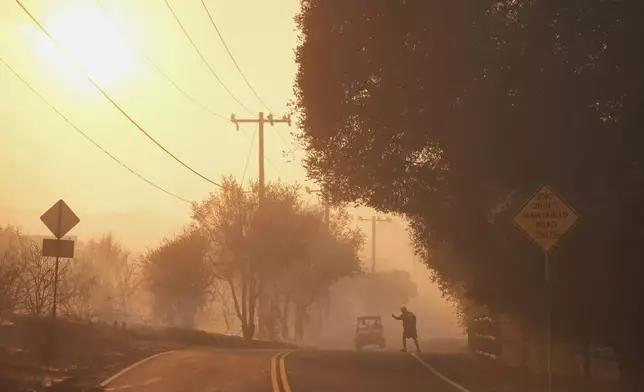 A resident gets a ride as people evacuate from the Canyon Fire on Thursday, Aug. 7, 2025, in Halsey Canyon, Calif. (AP Photo/Marcio Jose Sanchez)