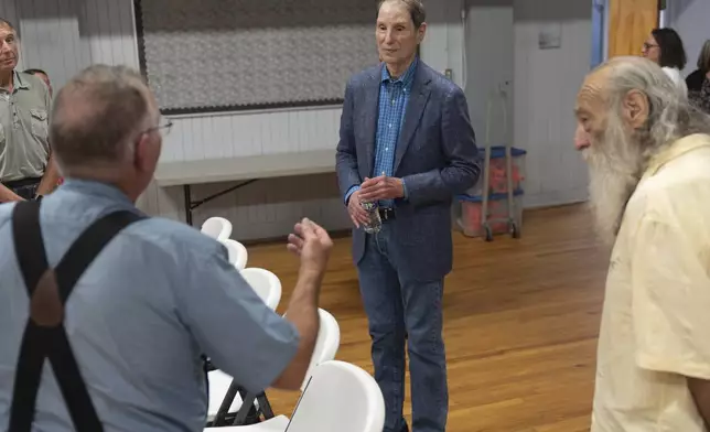 Sen. Ron Wyden, D-Ore., center, speaks to T.L. Fassbender, left, after a town hall meeting on Friday, July 25, 2025, in Wasco, Ore. (AP Photo/Jenny Kane)