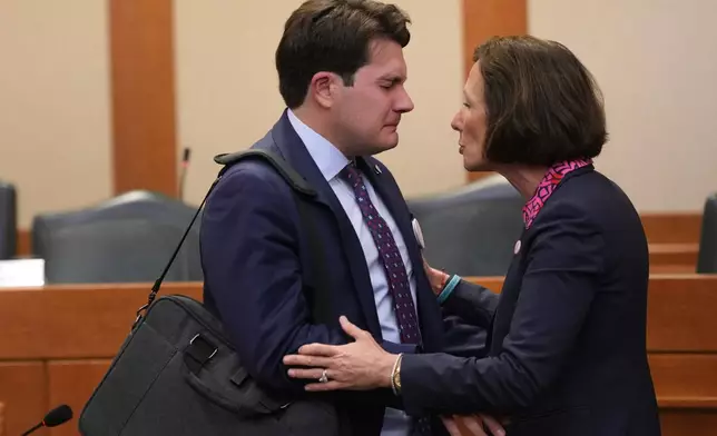ADDS NAME OF FATHER Sen. Lois Kolkhorst, R-Brenham, right, comforts Lars Hollis, left, father of Virginia who was lost to the recent flooding in Kerr County, following a Texas Senate hearing at the Texas Capitol, Wednesday, Aug. 20, 2025, in Austin, Texas. (AP Photo/Eric Gay)
