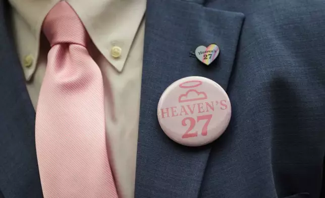 The parent of a child lost to the recent flooding in Kerr County wears a 'Heaven's 27' button during a Texas Senate hearing at the Texas Capitol, Wednesday, Aug. 20, 2025, in Austin, Texas. (AP Photo/Eric Gay)