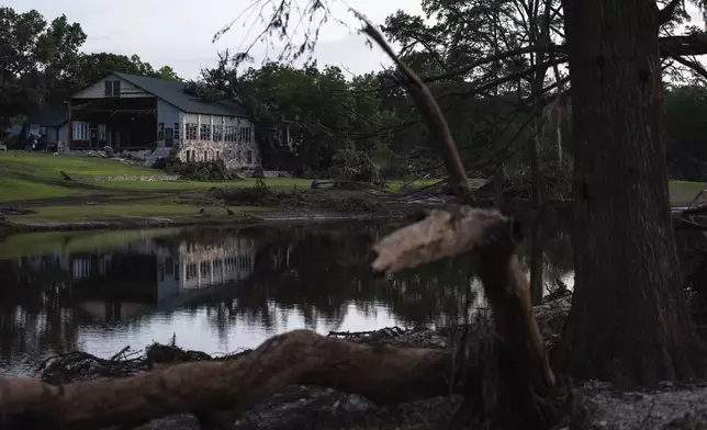 FILE - A building at Camp Mystic is reflected in water after a flash flood swept through the area, on July 7, 2025, in Hunt, Texas. (AP Photo/Eli Hartman, File)