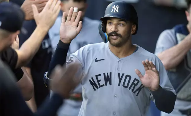 New York Yankees' Trent Grisham celebrates with teammates in the dugout after his solo home run. off Tampa Bay Rays pitcher Drew Rasmussen during the first inning of a baseball game Wednesday, Aug. 20, 2025, in Tampa, Fla. (AP Photo/Chris O'Meara)