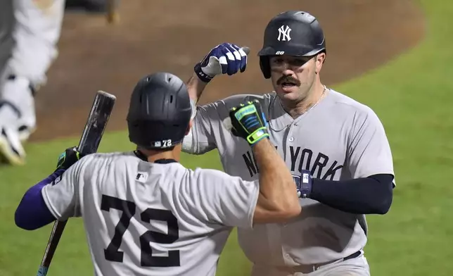 New York Yankees' Austin Wells (28) celebrates with José Caballero (72) after Wells hit a home run off Tampa Bay Rays pitcher Pete Fairbanks during the 10th inning of a baseball game Wednesday, Aug. 20, 2025, in Tampa, Fla. (AP Photo/Chris O'Meara)