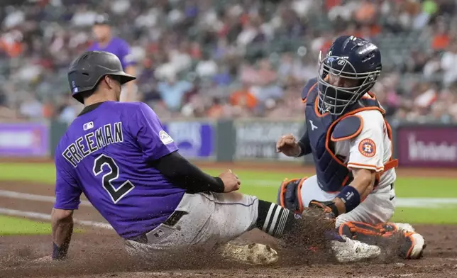 Colorado Rockies' Tyler Freeman (2) is tagged out at home plate by Houston Astros catcher César Salazar during the fifth inning of a baseball game Thursday, Aug. 28, 2025, in Houston. (AP Photo/David J. Phillip)