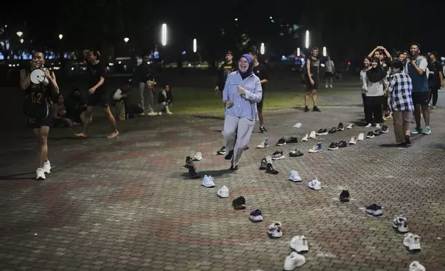 Akihiko Akira, left, the founder of Komunitas Bermain, ot Playing Community, gives directions to participants during a gathering in Jakarta, Indonesia, Friday, July 11, 2025. (AP Photo/Dita Alangkara)